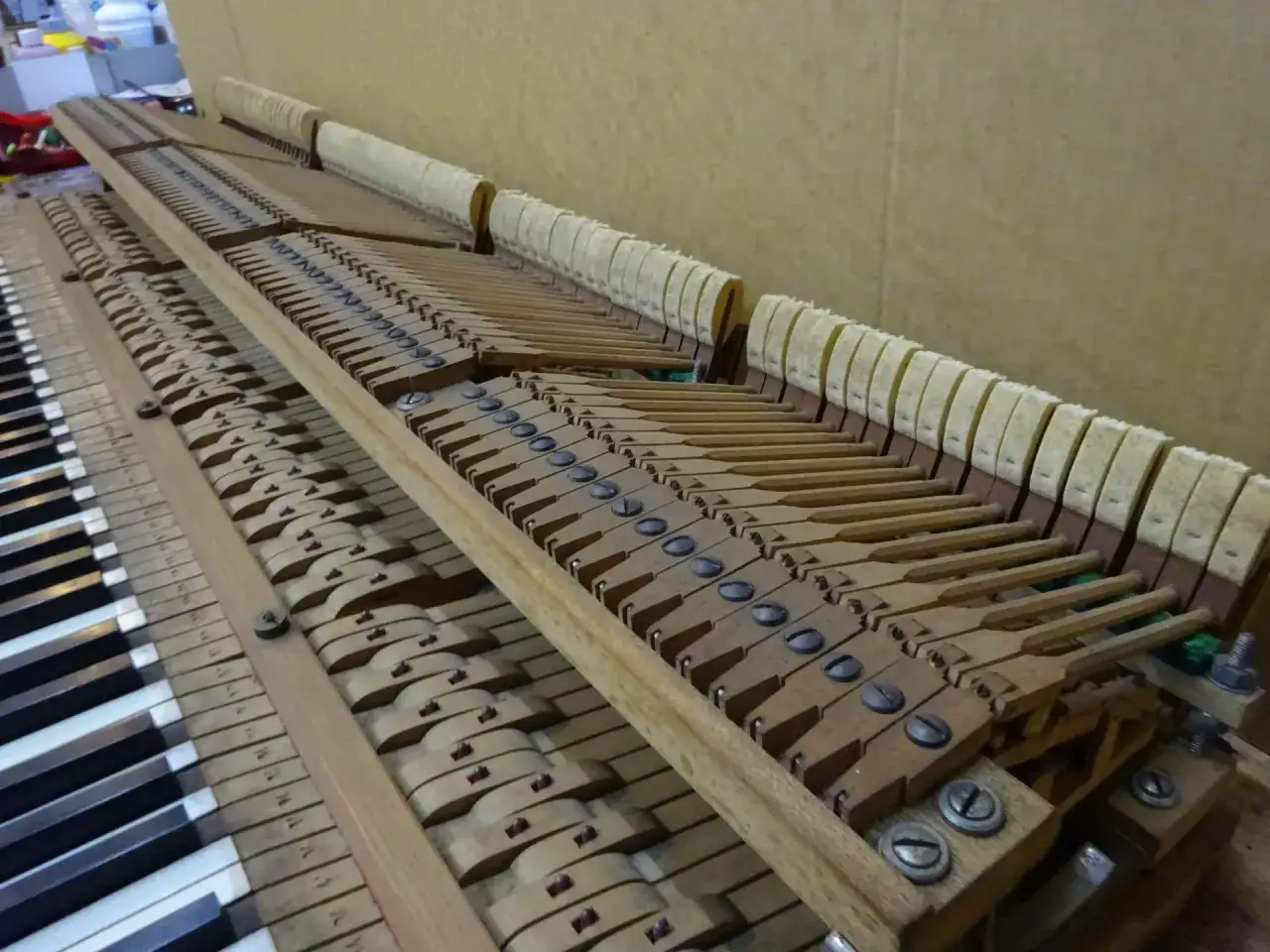M&eacute;canisme interne d'un piano, montrant les marteaux et les touches. Ce piano, membre de la famille d'instruments &agrave; clavier, est en cours de r&eacute;paration.